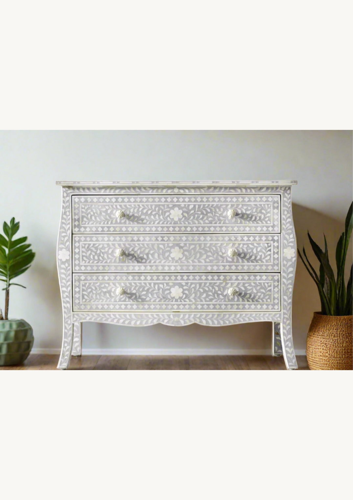 Decorative grey dresser with intricate bone inlay carvings on a neutral background
