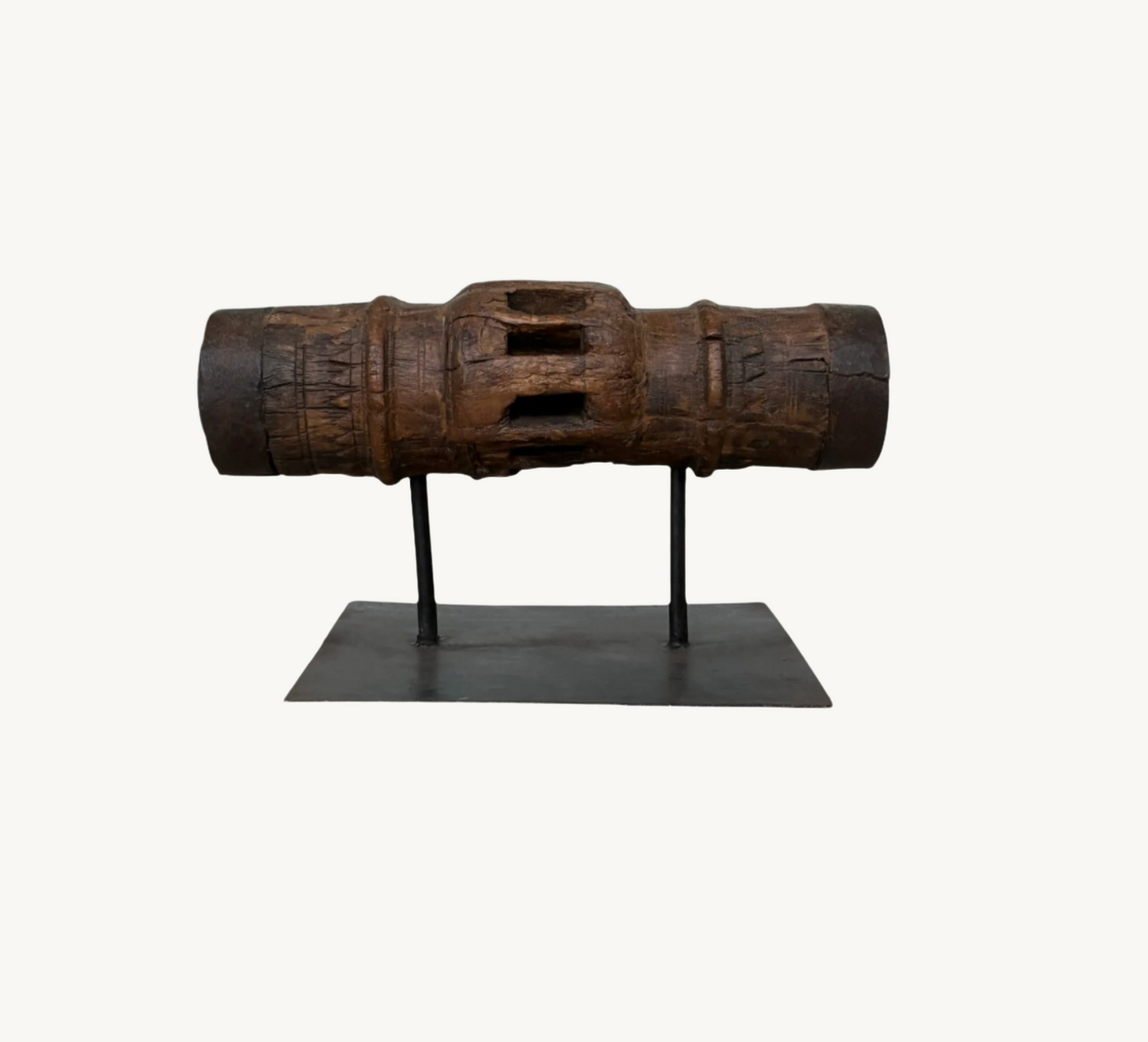 An old wooden carriage wheel hub with visible weathering, displayed on a metal stand.
