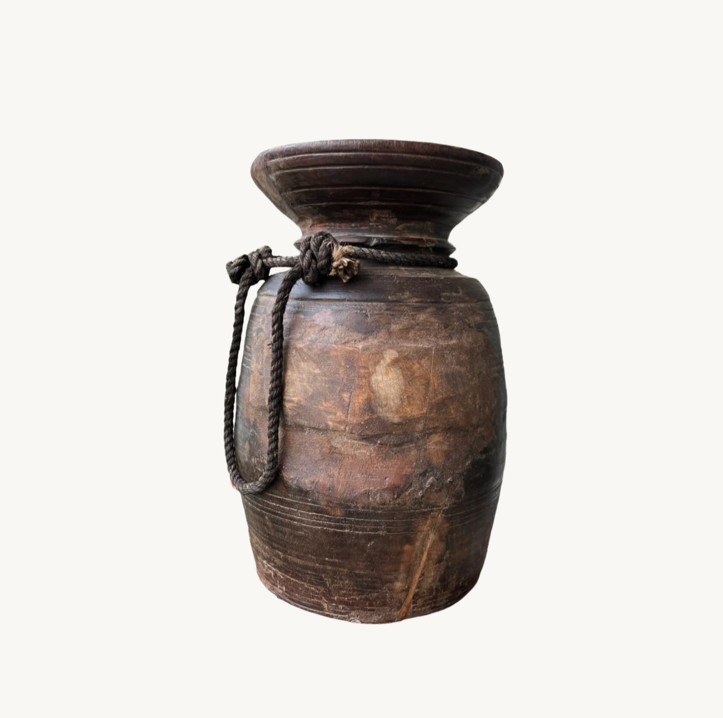 Antique Himalayan teak wood pot with visible weathering and a rope handle, isolated on a white background.
