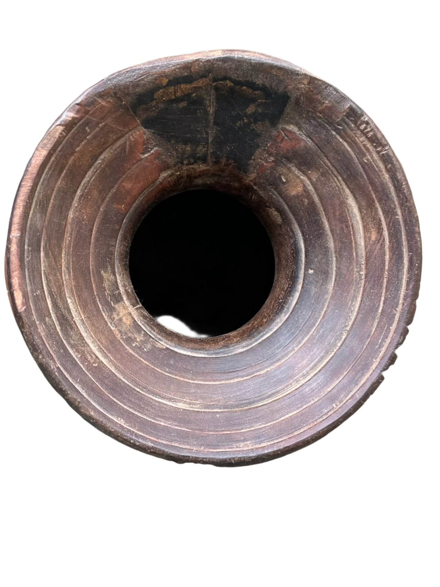 A hand-carved, vintage, rustic Himalayan pot made of teakwood with a rope handle, showing natural wear and age.