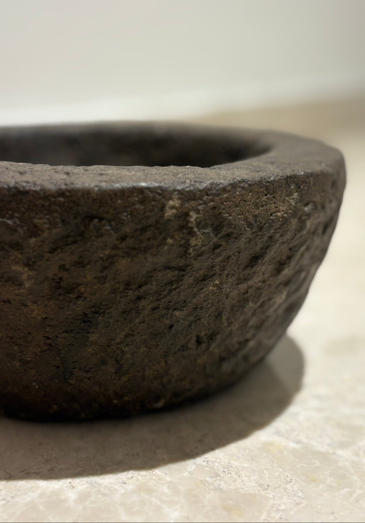 Close-up of a dark stone bowl on a light surface