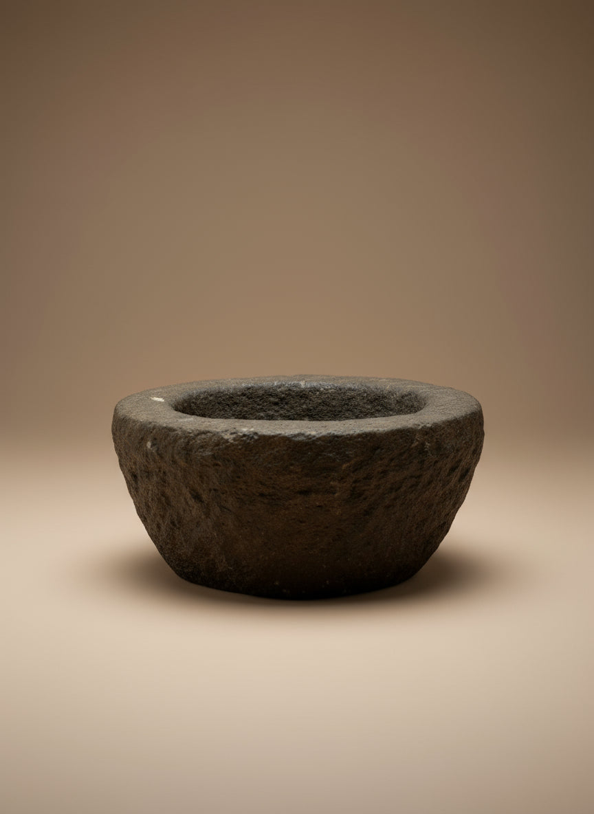 Dark stone antique bowl on a beige background