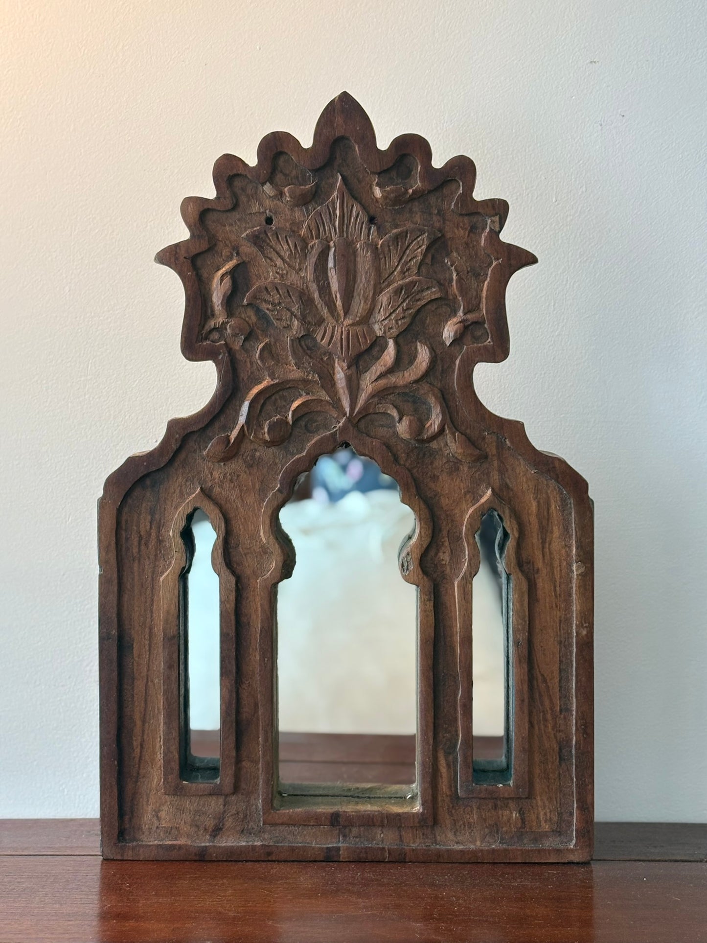 Wooden mirror with intricate carvings on a white background