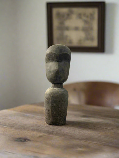 A hand sculpted terracotta statue with an abstract design, depicting a figure standing upright.