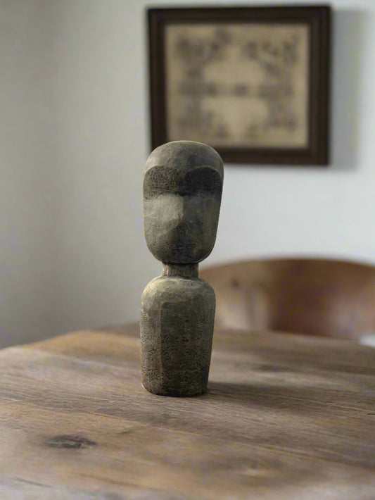 A hand sculpted terracotta statue with an abstract design, depicting a figure standing upright.