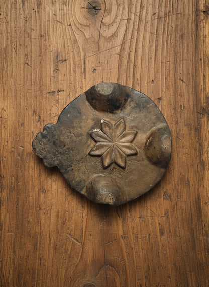 Decorative stone object with star design on a gray background