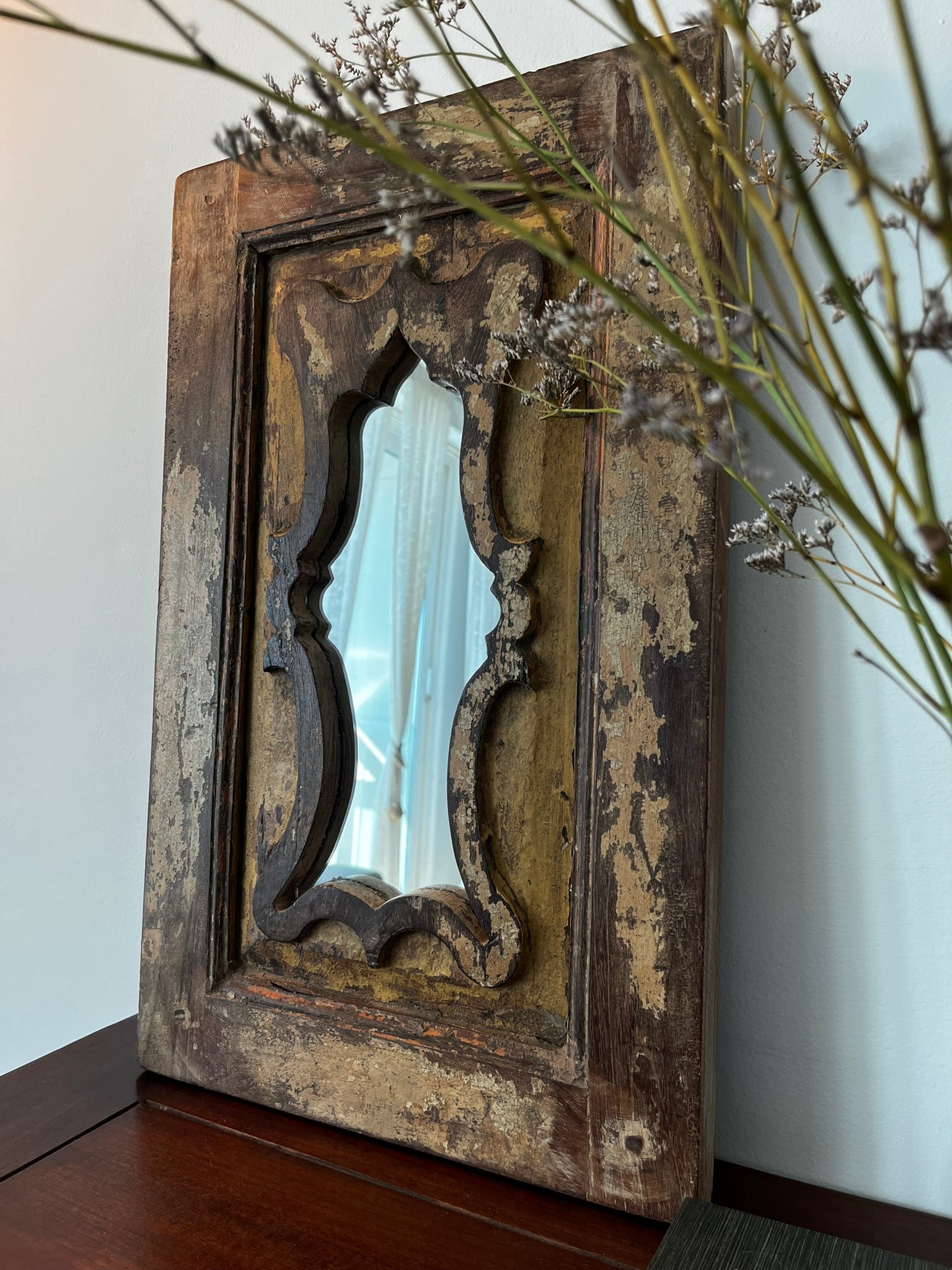 A vintage teakwood mirror with a decorative frame, featuring mirror within a mirror design, with hooks for hanging.