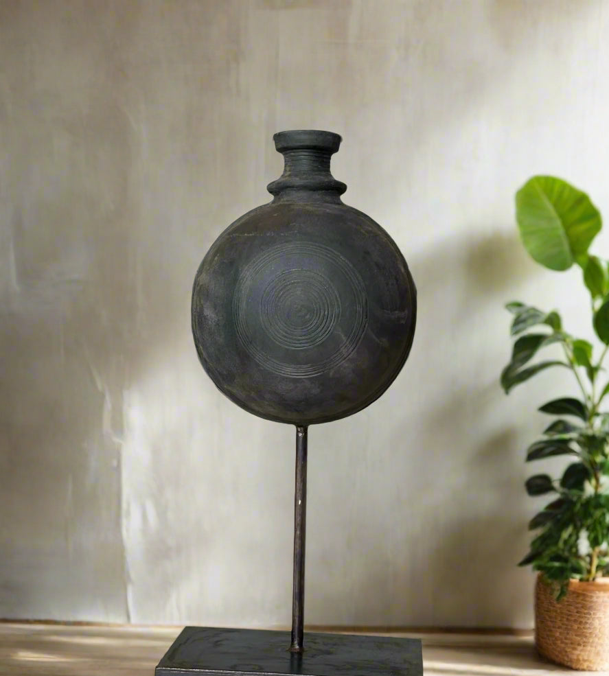 handmade black vase on a stand in a room 