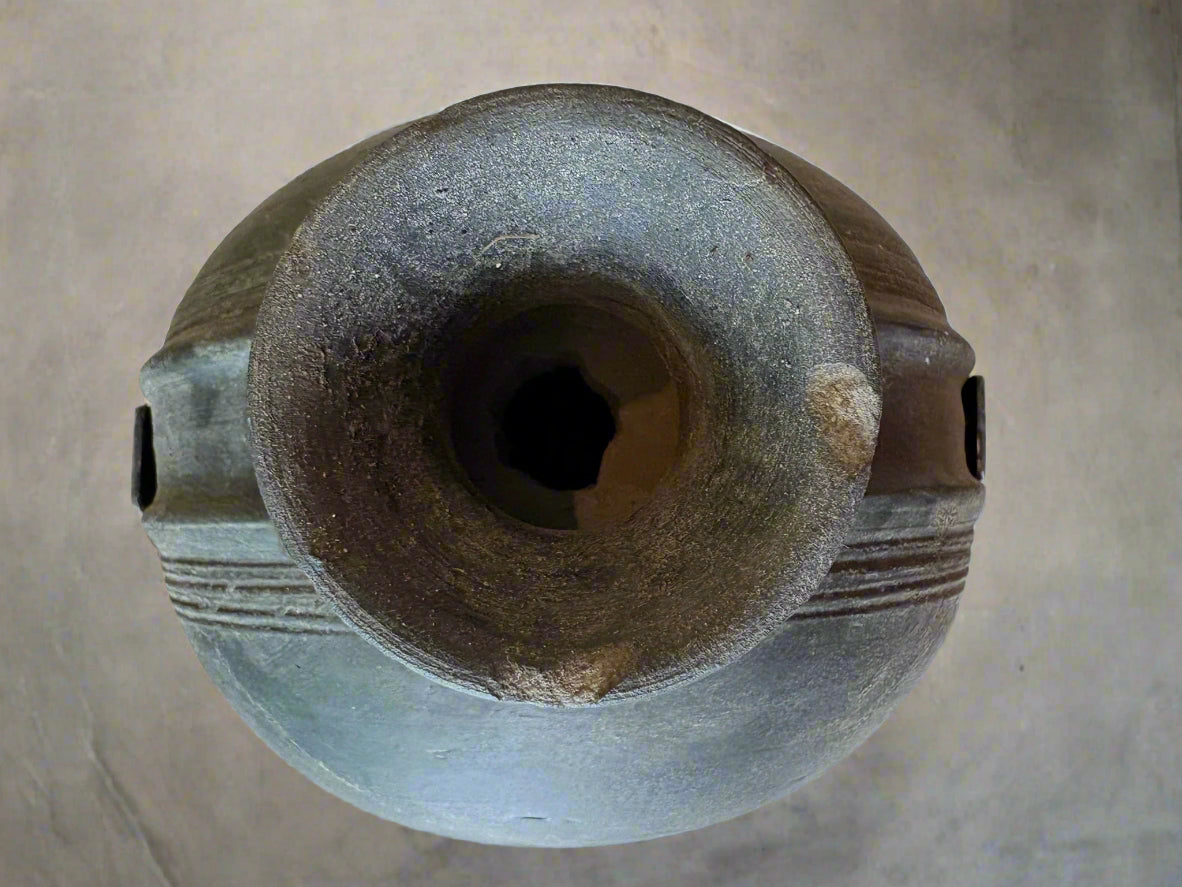 Top view of a black pot on a light-colored floor.