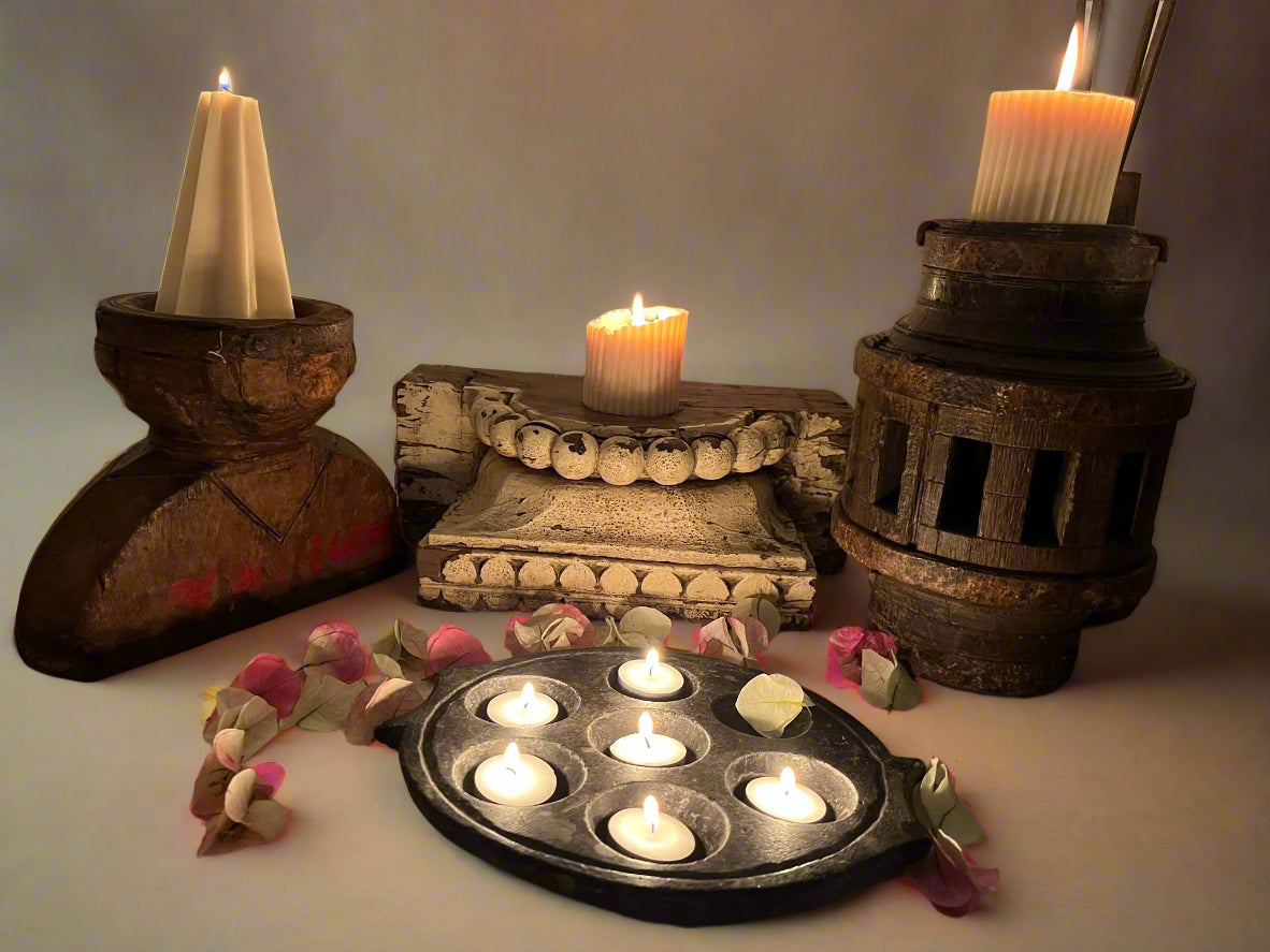 a group of candle stands made from Indian antique objects