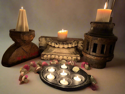 a group of candle stands made from Indian antique objects