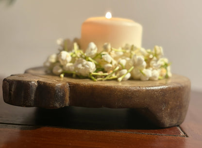 Candle on a marble platform with white flowers