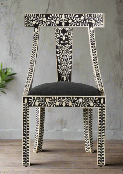 Decorative inlay chair with intricate black and white patterns on a wooden floor.