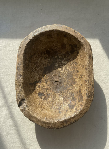 Vintage marble bowl with patina on a wooden surface