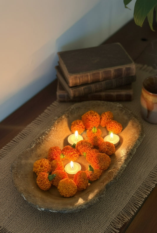 Decorative arrangement of marigold flowers and candles on a vintage marble tray 