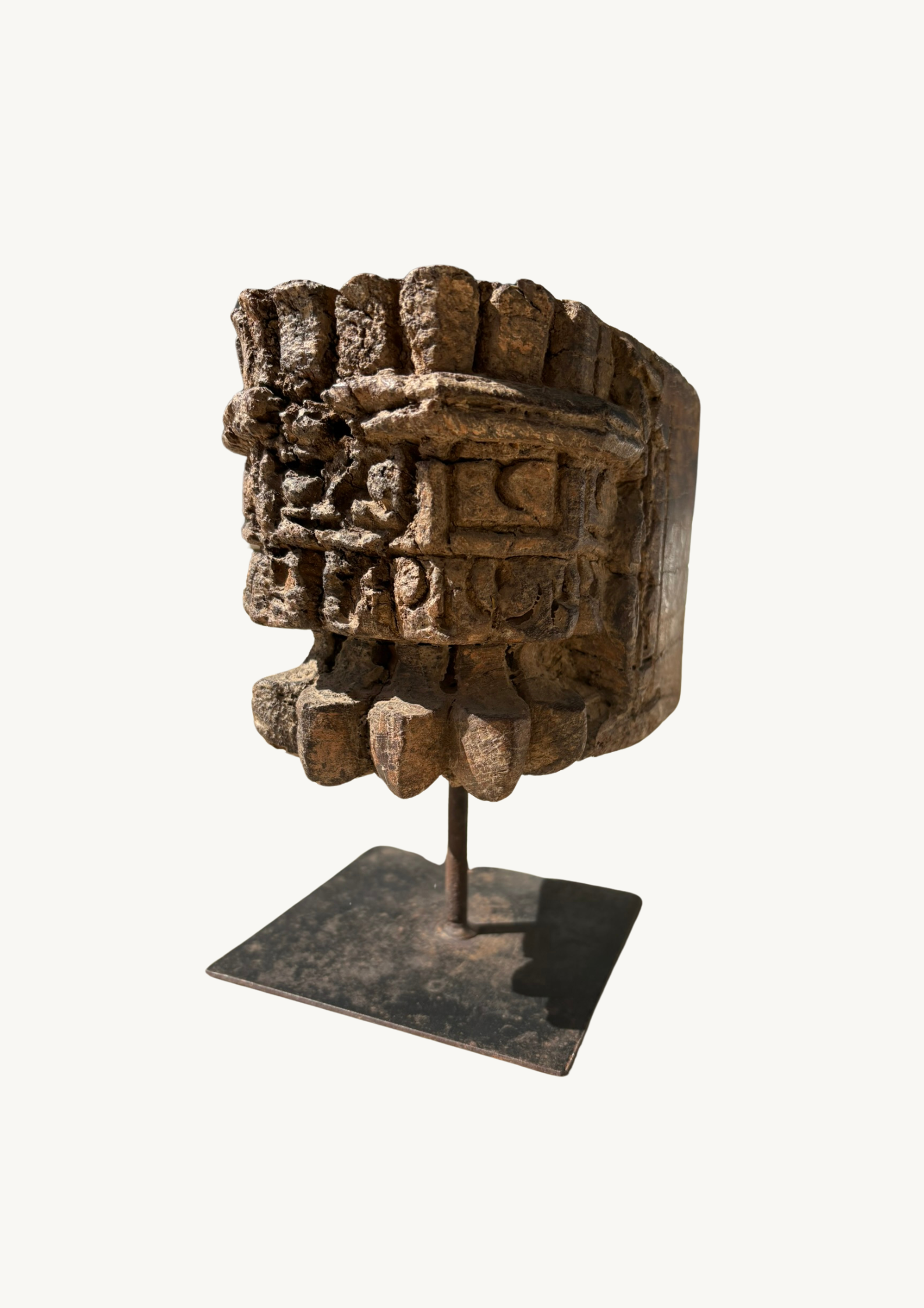 A vintage pillar candle base made of old teakwood, featuring ethnic motifs and hand-carved details, displayed on a metal stand.